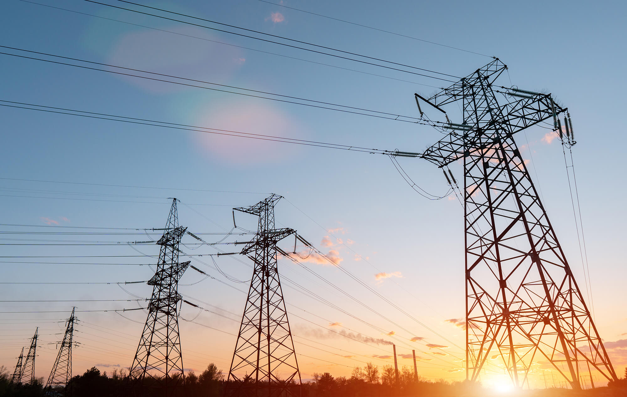Poteaux électriques devant un coucher de soleil.